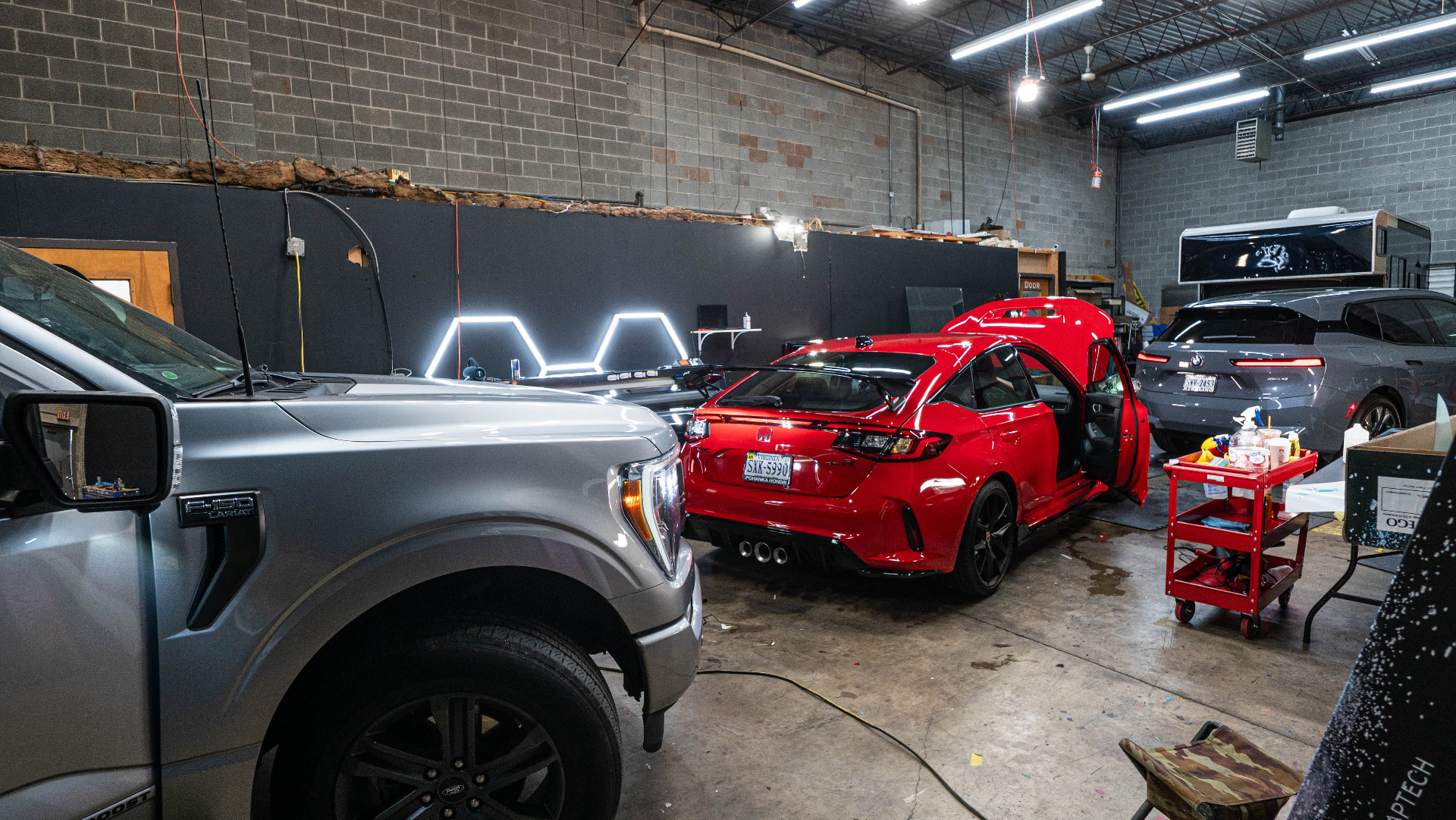 Wide view of the Skyline Customs installation bay in Chantilly, VA with vehicles staged for work