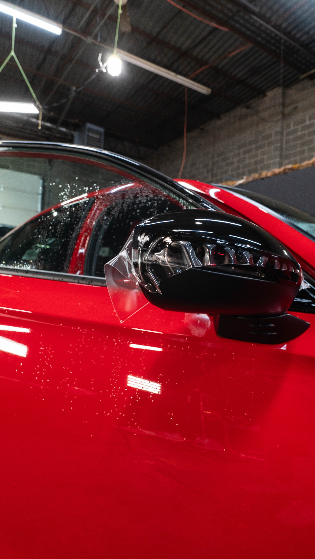 Close-up of freshly installed window film on a red vehicle at Skyline Customs